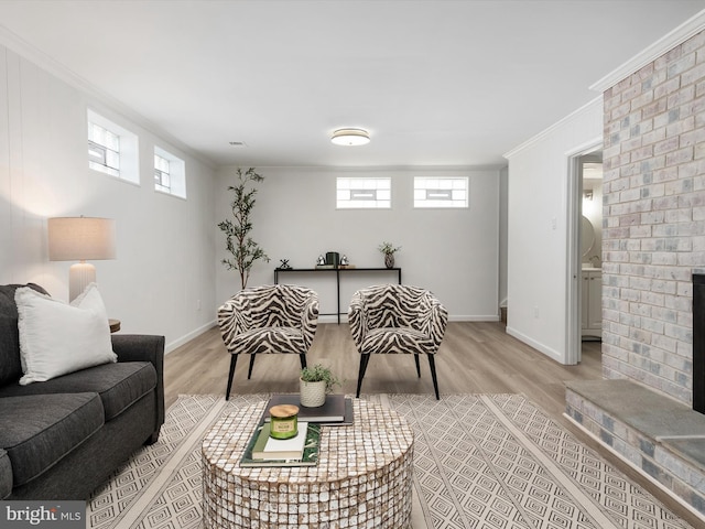 living area with plenty of natural light, a fireplace, crown molding, and wood finished floors