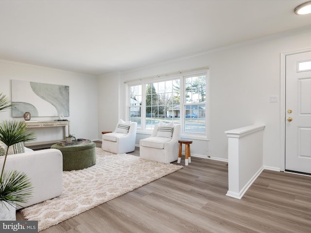 living room with ornamental molding, baseboards, and wood finished floors