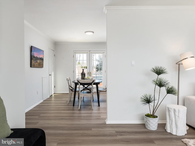 dining area featuring baseboards, wood finished floors, and crown molding