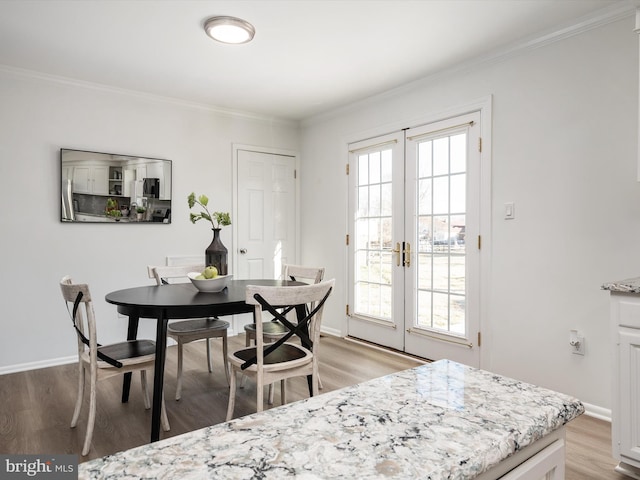 dining space with crown molding, a healthy amount of sunlight, and light wood-style floors