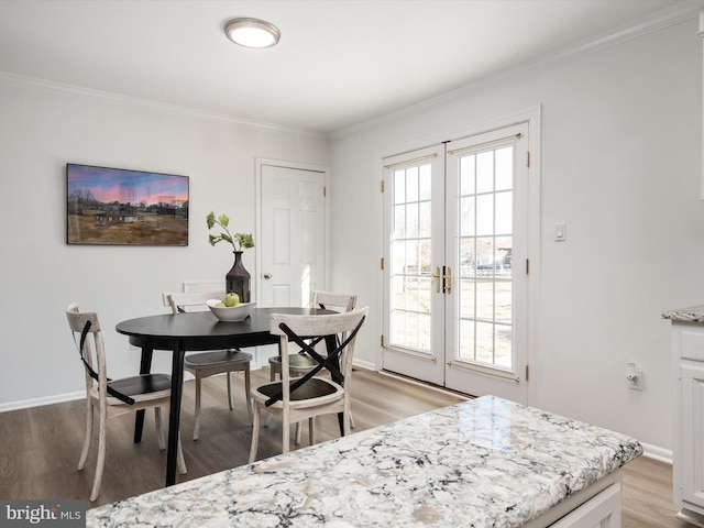 dining room featuring light wood-type flooring, plenty of natural light, and crown molding