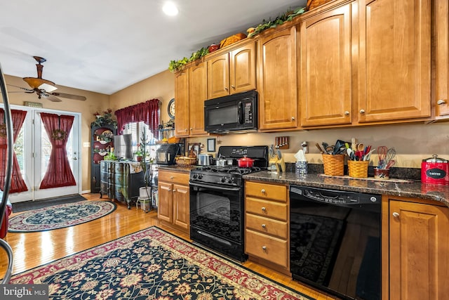 kitchen featuring brown cabinets, light wood-style floors, black appliances, and a ceiling fan