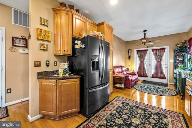 kitchen with visible vents, black fridge with ice dispenser, light wood finished floors, baseboards, and ceiling fan