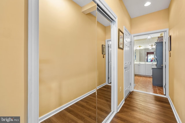 corridor featuring dark wood finished floors and baseboards