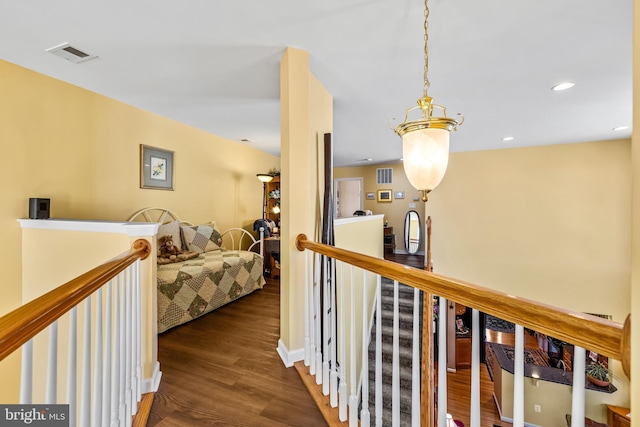 corridor with an upstairs landing, visible vents, recessed lighting, and wood finished floors