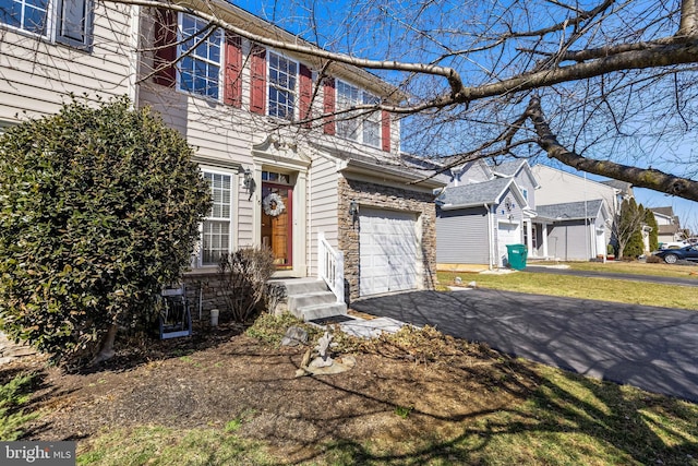 view of front facade with aphalt driveway and an attached garage