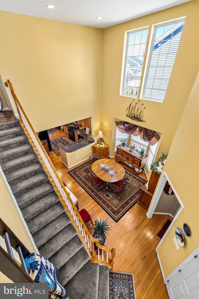 living area with recessed lighting, stairway, and hardwood / wood-style floors