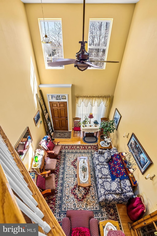 living area with a chandelier, a towering ceiling, and wood finished floors