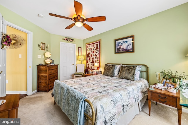 bedroom featuring baseboards, light carpet, and ceiling fan