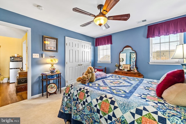 bedroom featuring fridge, multiple windows, visible vents, and a closet