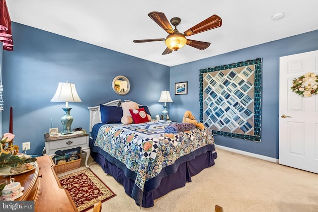 carpeted bedroom with ceiling fan and baseboards