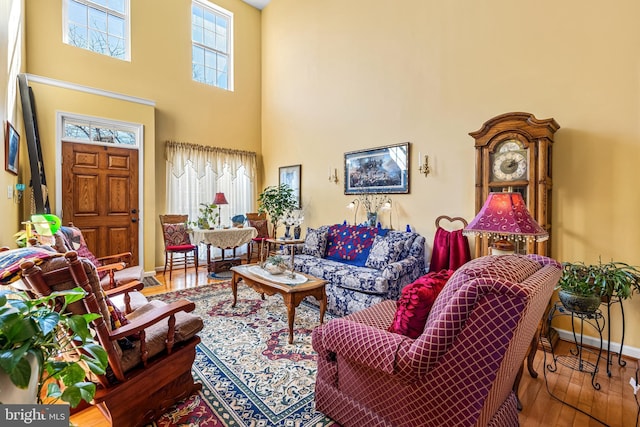 living room with a high ceiling, wood finished floors, and baseboards