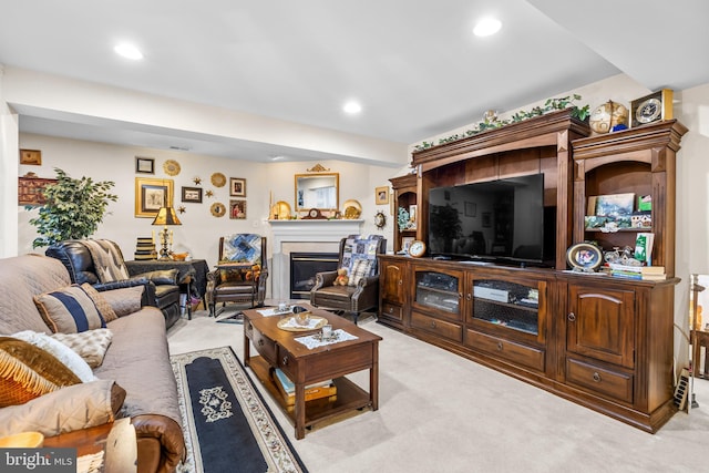 living room with light carpet, a glass covered fireplace, and recessed lighting