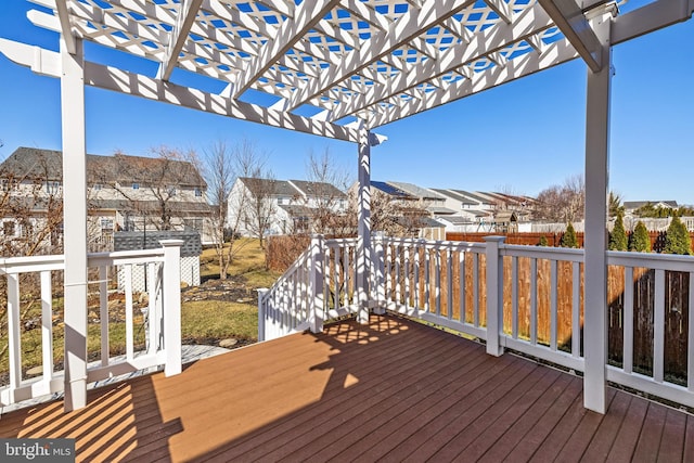 wooden terrace with a residential view, a pergola, and fence