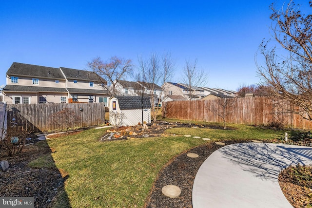 view of yard with an outbuilding, a patio, a storage unit, and a fenced backyard