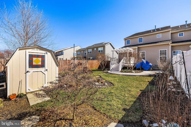 view of yard with a residential view, a pergola, a fenced backyard, an outdoor structure, and a storage unit