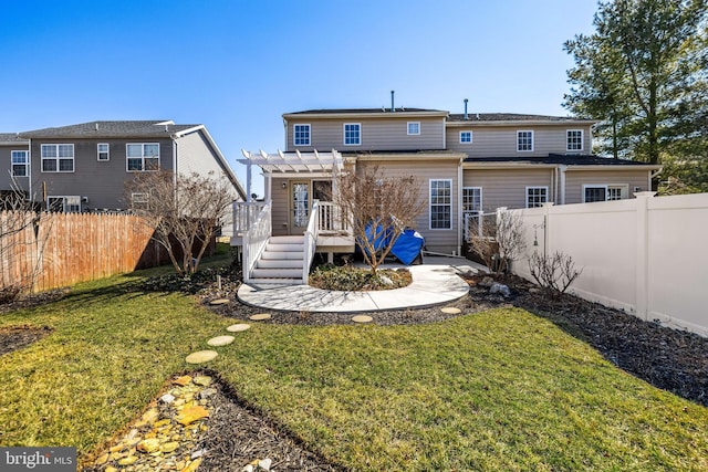 back of property with a deck, a lawn, a fenced backyard, and a pergola