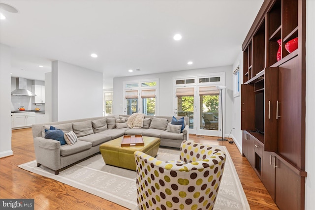 living area with recessed lighting, light wood-type flooring, and baseboards