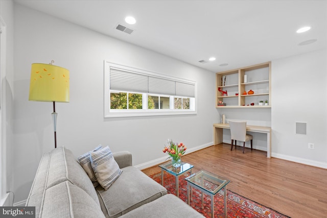 living area with visible vents, wood finished floors, recessed lighting, baseboards, and built in study area