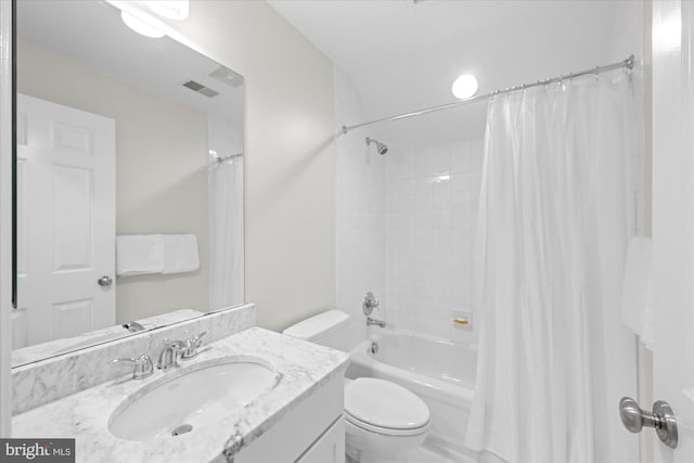 bathroom featuring vanity, toilet, visible vents, and shower / bath combo with shower curtain