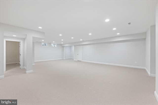 below grade area with visible vents, recessed lighting, baseboards, and light carpet