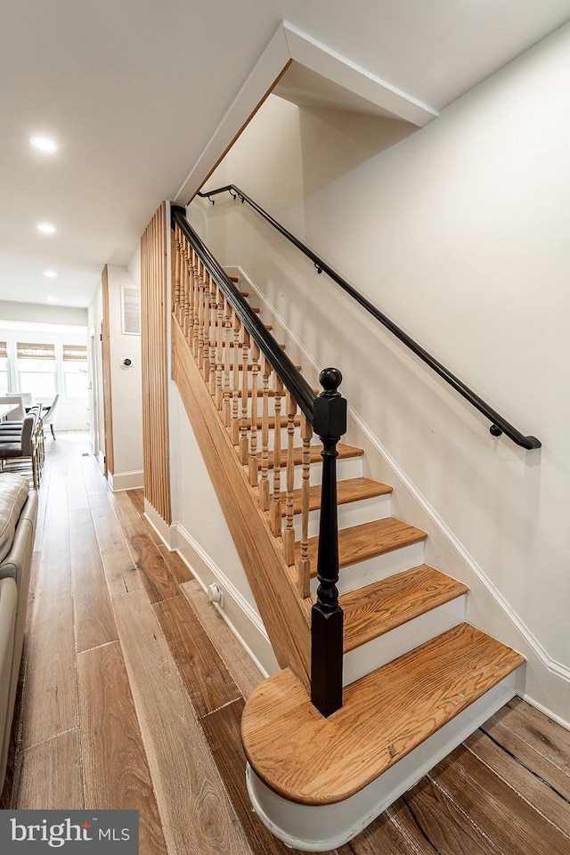 stairway featuring recessed lighting, baseboards, and hardwood / wood-style flooring