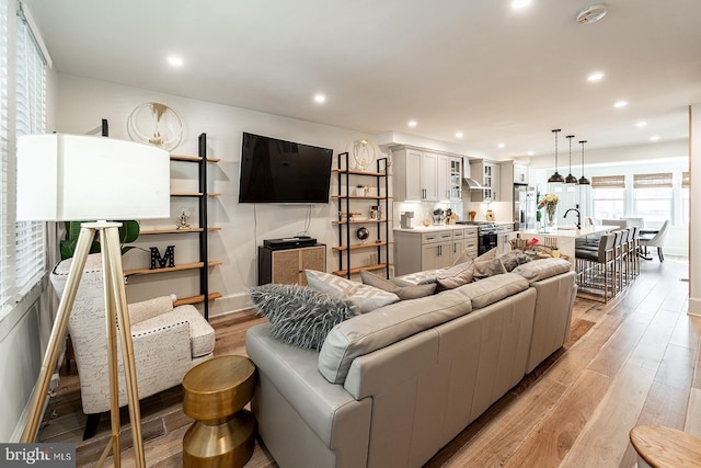 living area with light wood-style floors and recessed lighting