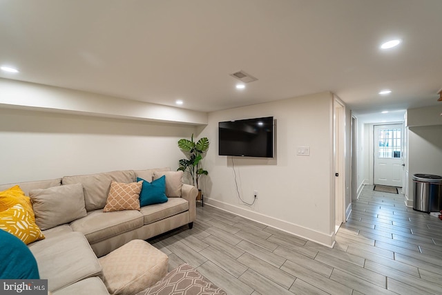 living room featuring wood tiled floor, visible vents, baseboards, and recessed lighting