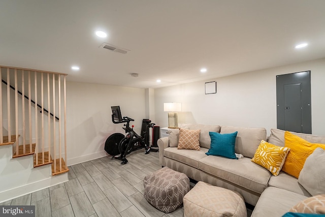 living area featuring electric panel, visible vents, wood tiled floor, stairs, and recessed lighting