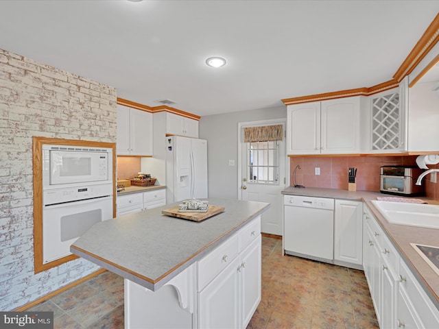 kitchen featuring white appliances, a sink, visible vents, white cabinetry, and light countertops