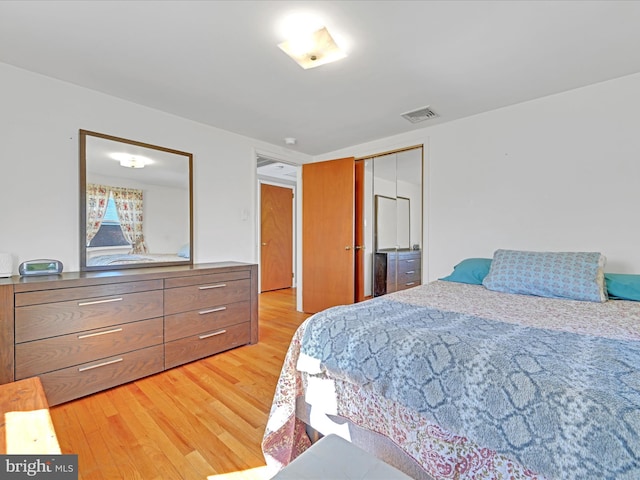 bedroom with a closet, light wood-type flooring, and visible vents