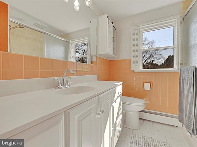 full bathroom with tile walls, a baseboard heating unit, a stall shower, vanity, and tile patterned flooring