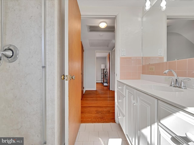 bathroom with tile patterned flooring, visible vents, vanity, and decorative backsplash