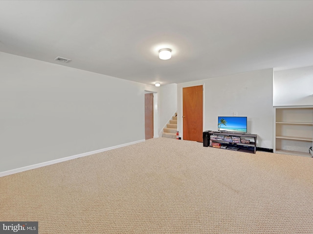 finished basement featuring carpet, stairs, visible vents, and baseboards