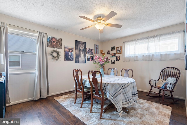 dining space featuring a textured ceiling, hardwood / wood-style floors, a ceiling fan, and baseboards