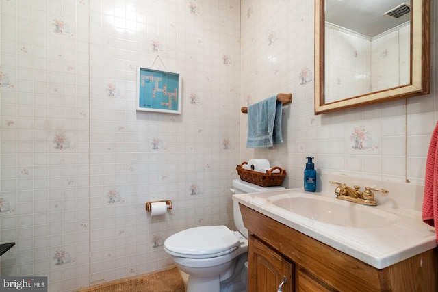 bathroom featuring toilet, vanity, and visible vents