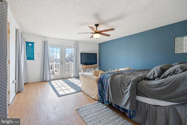 bedroom featuring access to outside, a textured ceiling, wood finished floors, and french doors