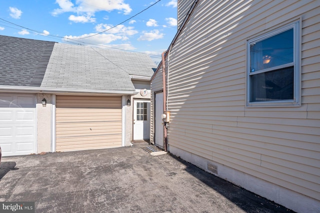 view of property exterior with a garage, crawl space, and a shingled roof