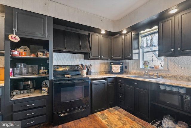 kitchen with black appliances, wood finished floors, a sink, and light countertops