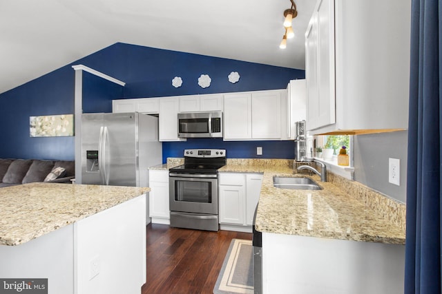 kitchen with a sink, dark wood-style floors, white cabinetry, stainless steel appliances, and lofted ceiling