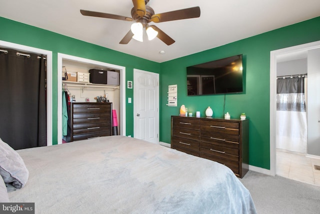 carpeted bedroom with tile patterned floors, a ceiling fan, and baseboards