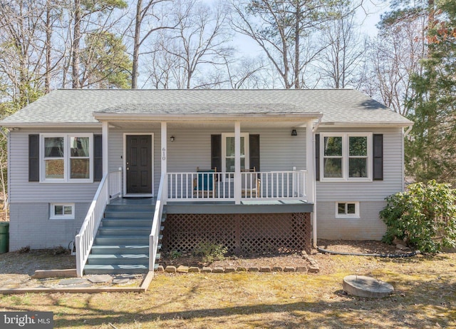 view of front of home featuring stairs, covered porch, and roof with shingles