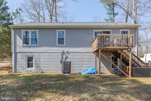 back of property with stairs, a deck, and a yard