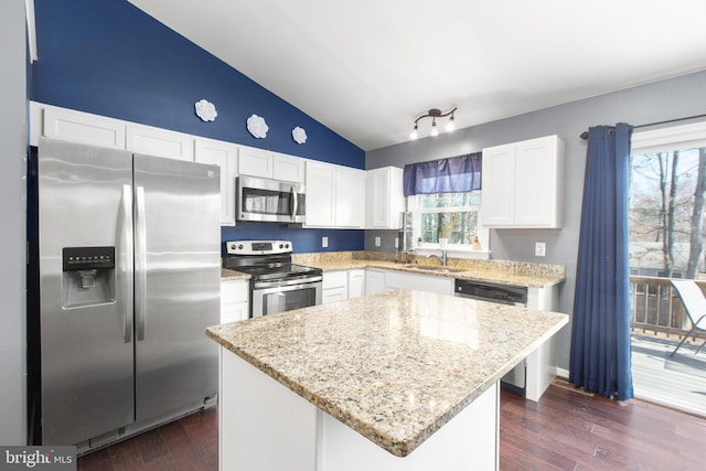 kitchen featuring appliances with stainless steel finishes, white cabinetry, dark wood-type flooring, and vaulted ceiling