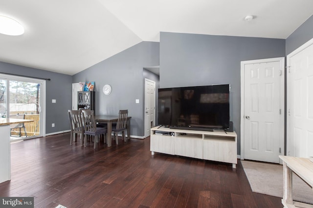 living room with baseboards, lofted ceiling, and dark wood-type flooring