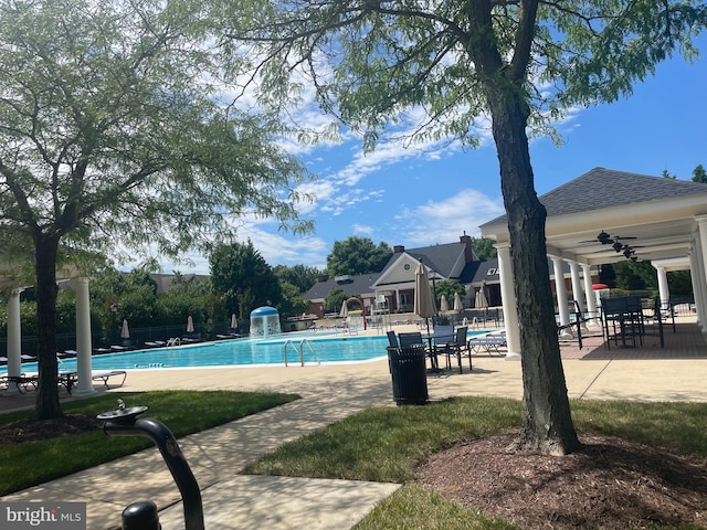 community pool with fence and a patio