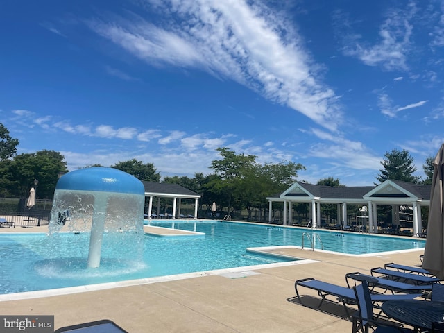 community pool with fence and a patio