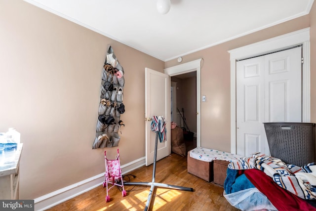 bedroom featuring crown molding, baseboards, and wood finished floors