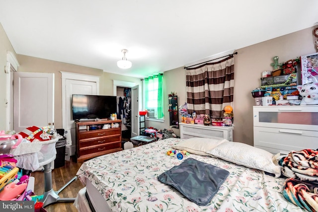 bedroom with cooling unit and wood finished floors