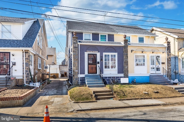 view of front facade featuring stucco siding, concrete driveway, and entry steps